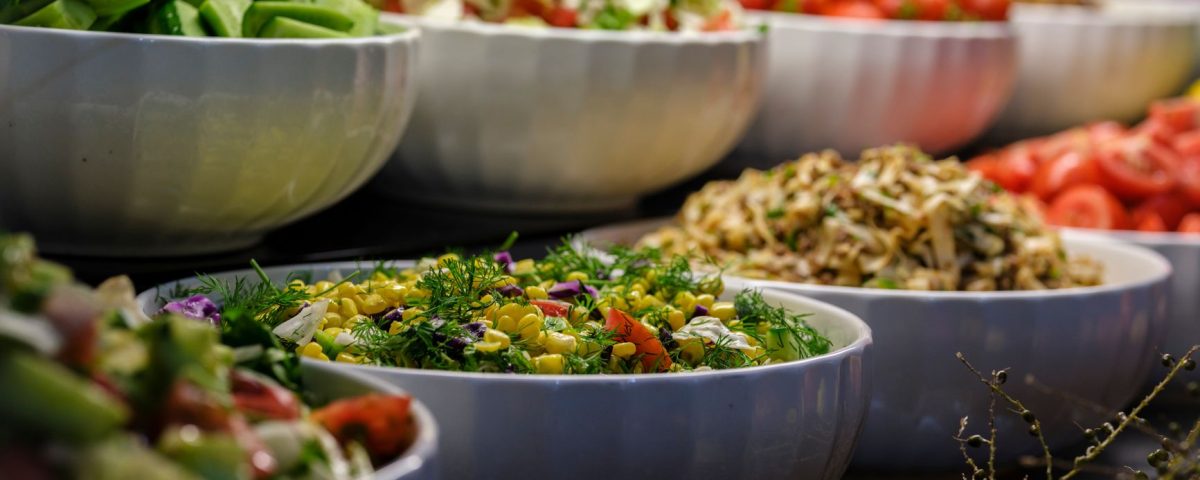 Berbagai bahan segar untuk salad sayur: selada, tomat, mentimun, wortel, paprika, dan jagung manis