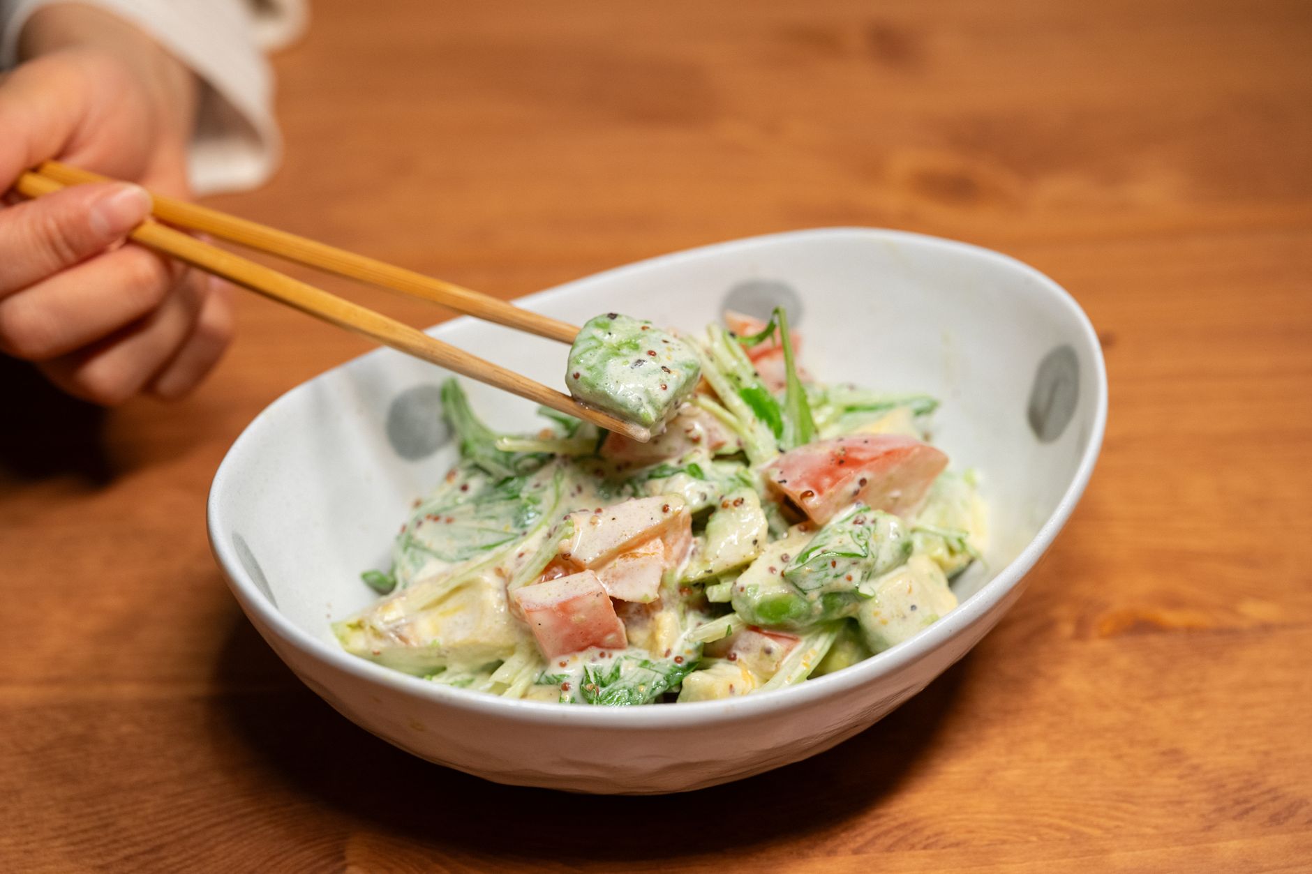 Campuran salad sayur segar dengan daun selada, tomat, timun, dan wortel, disajikan dalam mangkuk cantik.