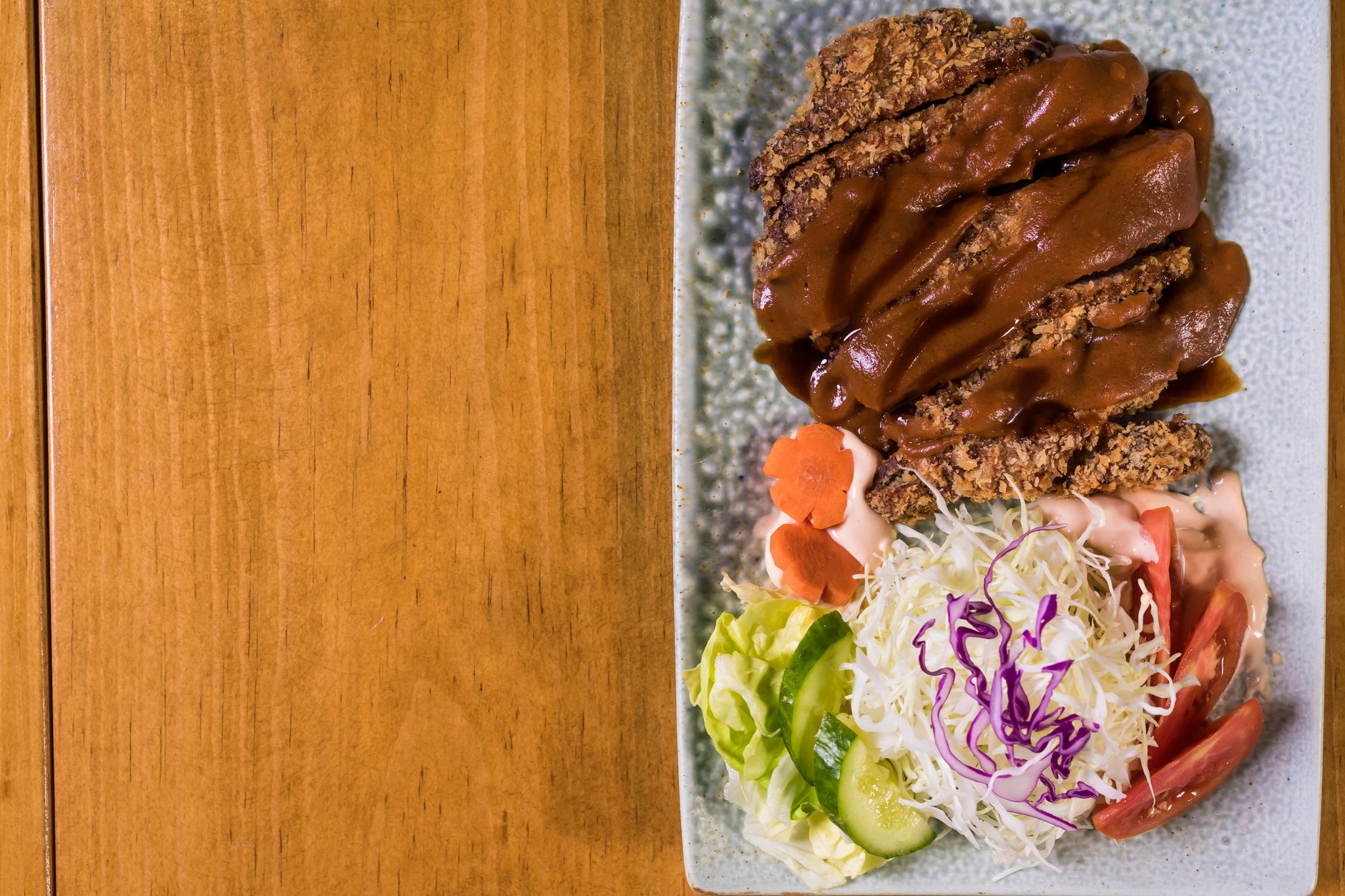 Box katsu berisi potongan daging empuk, sayuran segar, dan saus katsu krispi dalam kemasan praktis