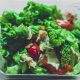 Salad segar berwarna hijau dengan tomat, mentimun, selada, dan dressing zaitun, cocok untuk diet sehat.