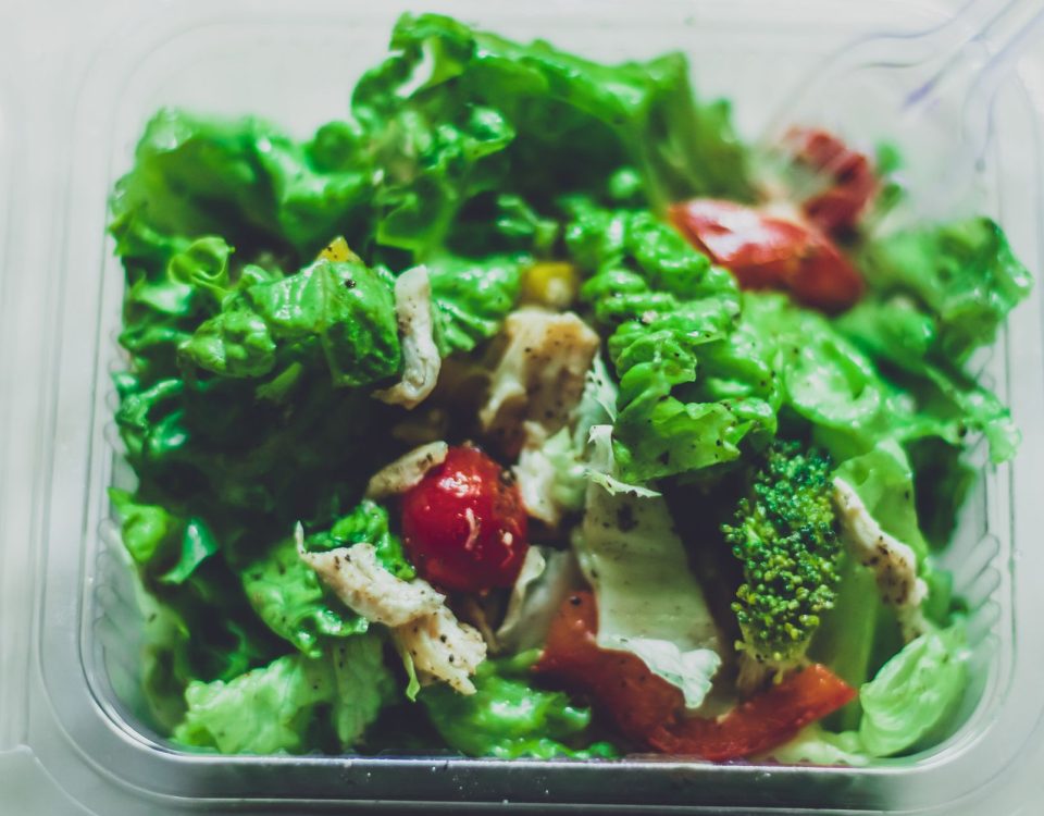 Salad segar berwarna hijau dengan tomat, mentimun, selada, dan dressing zaitun, cocok untuk diet sehat.