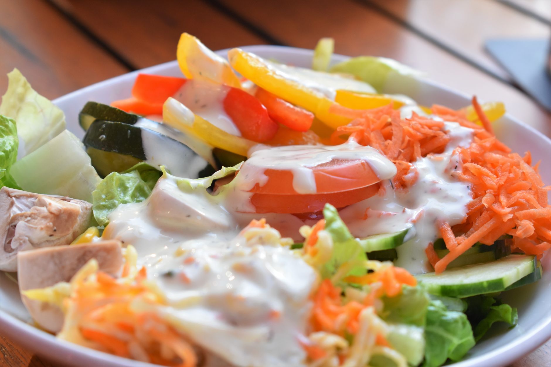 Dressing segar berwarna hijau melapisi sayuran salad renyah dengan minyak zaitun, lemon, dan bumbu herbal.