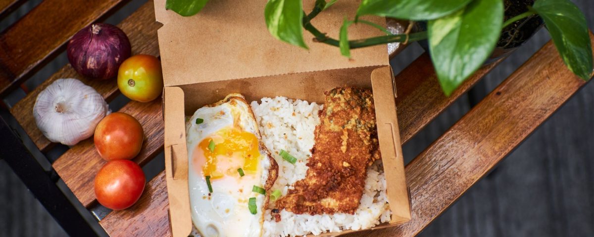 Nasi dalam kotak dengan potongan chicken katsu renyah, saus tonkatsu, dan sayuran segar