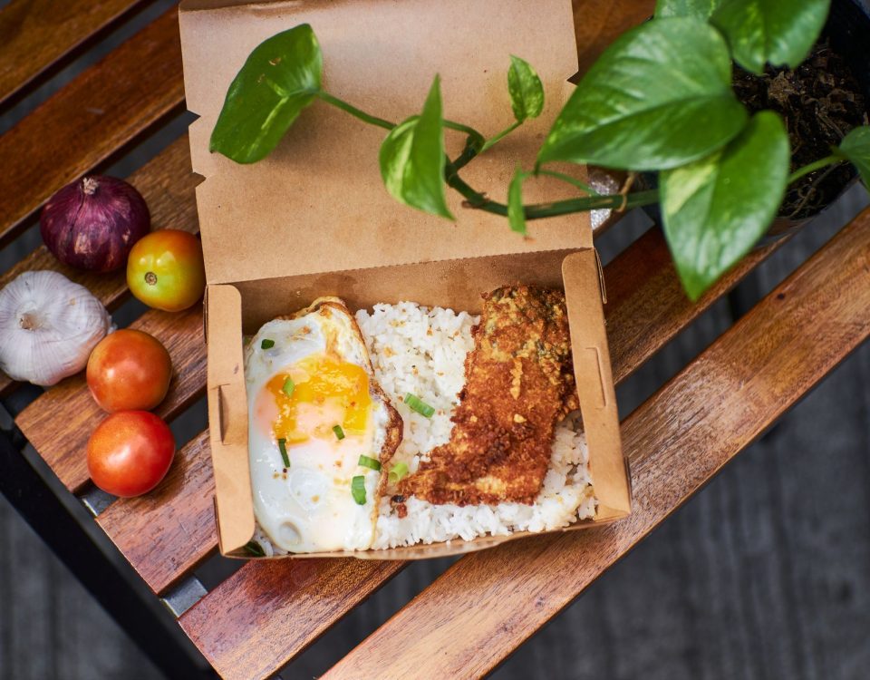 Nasi dalam kotak dengan potongan chicken katsu renyah, saus tonkatsu, dan sayuran segar