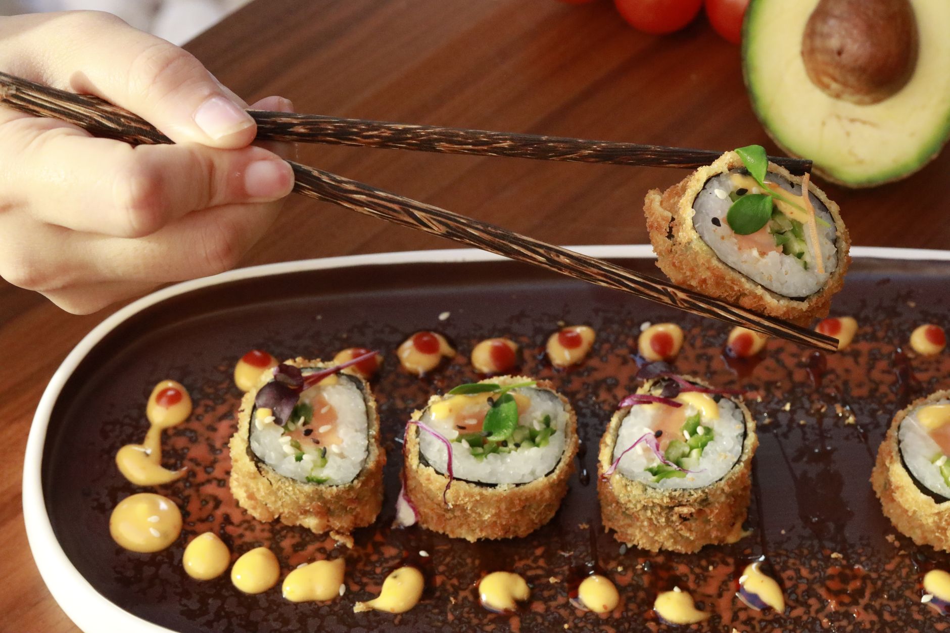 Foto sushi roll khas Katsusushi dengan irisan salmon segar dan saus spesial di atas piring kayu.